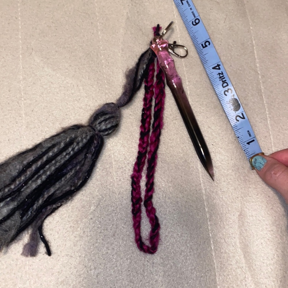 Pink and black resin self-defense keychain with white feather